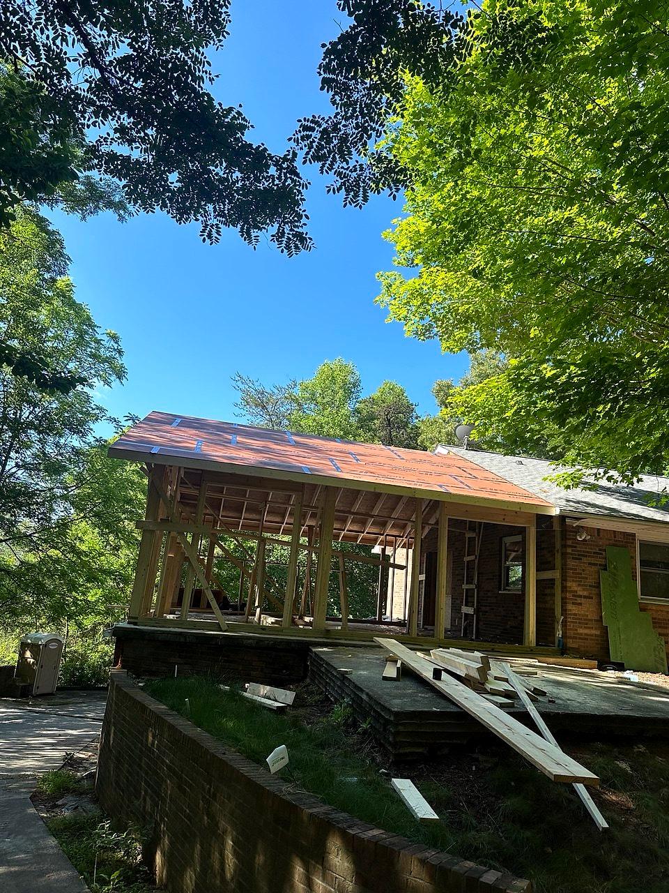 Addition framed onto a brick ranch under the trees