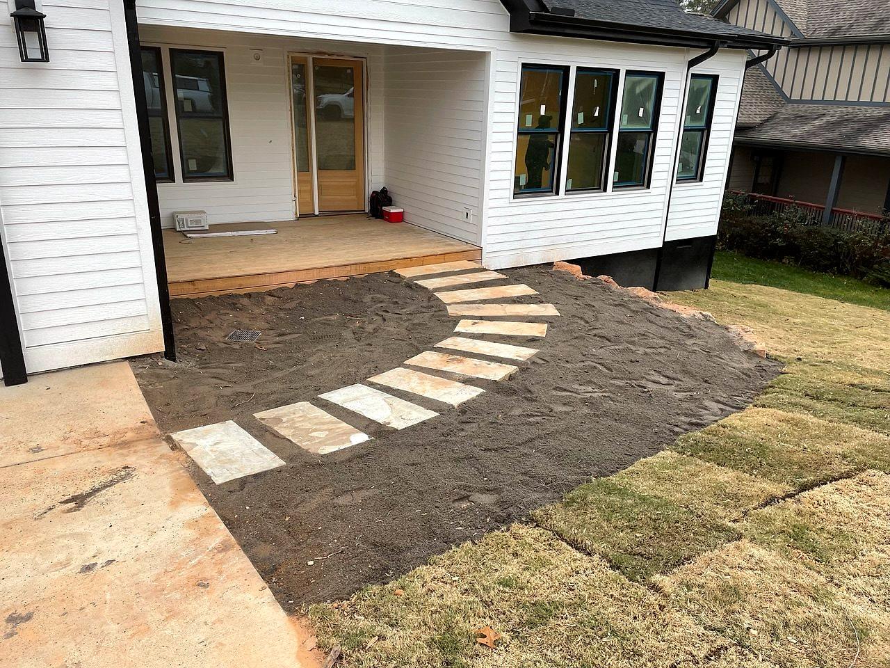 New patio and curved stepping-stone path laid into fresh sod