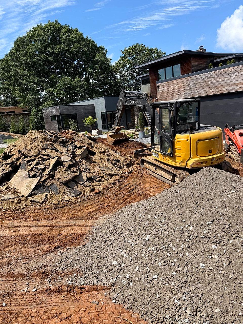 Excavator and gravel on the Town Mountain site during hardscape work