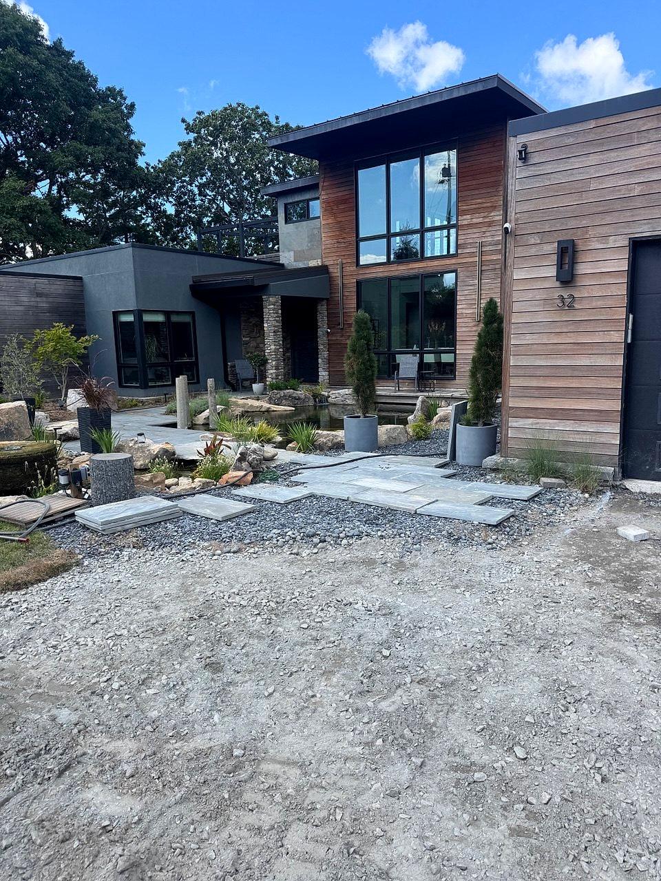 Modern Town Mountain residence with cedar and dark-panel siding above a new stone courtyard