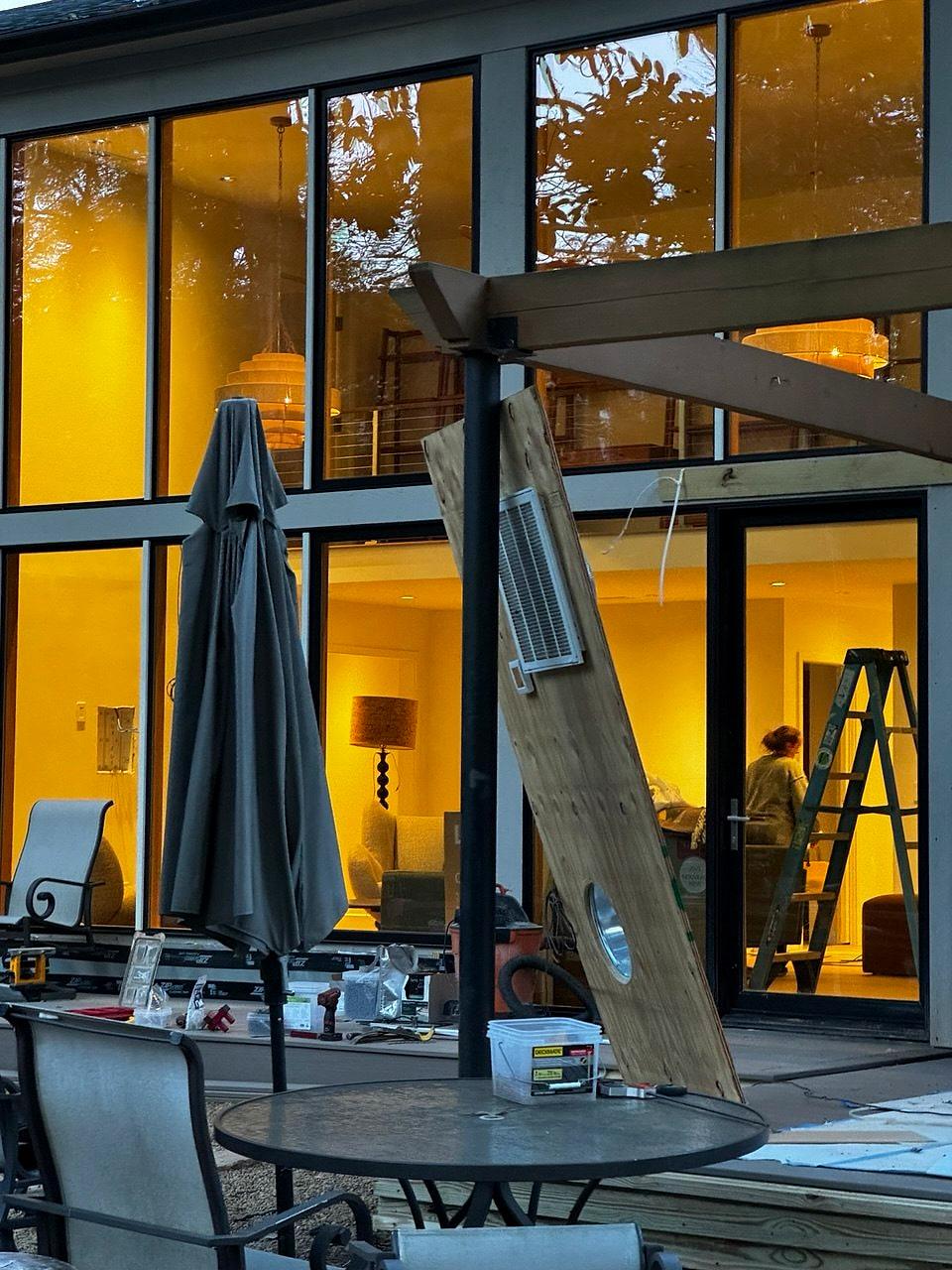 New two-story glass wall lit from inside at dusk